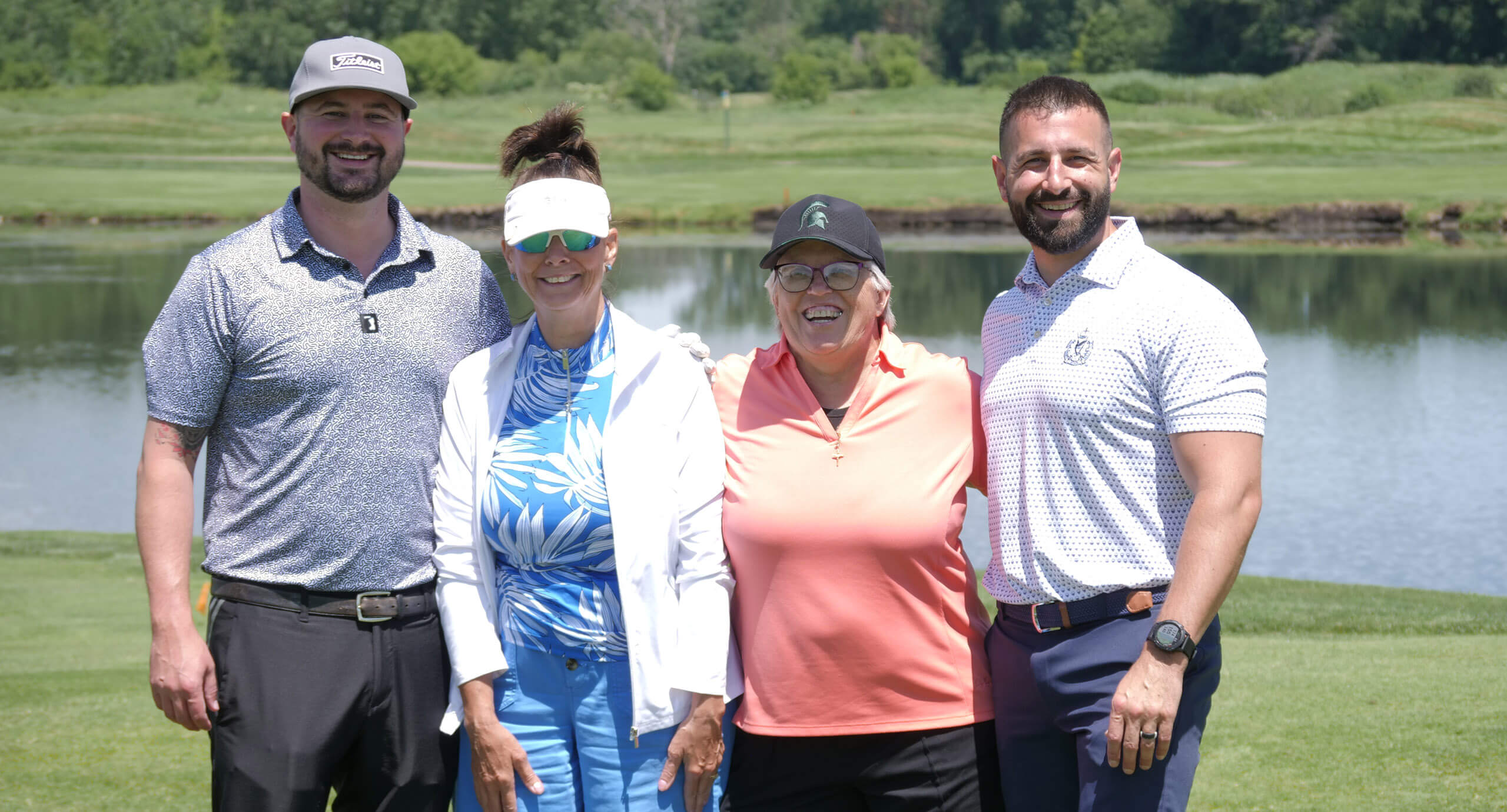 a team of 4 stand together on a golf course