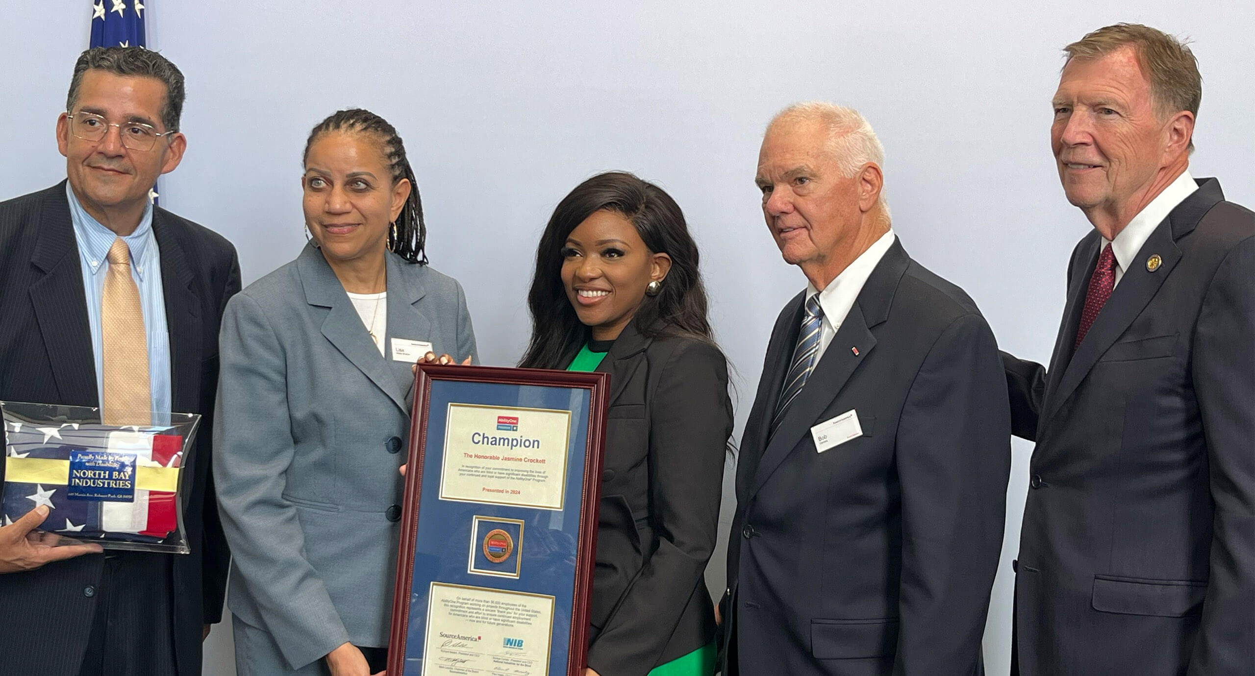 five people standing for a photo while two women hold a framed Champion certificate